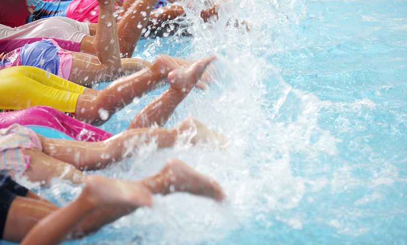 A group of children at a pool learning to swim.