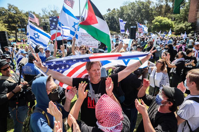 Demonstrators rally for Israel as pro Palestine counter demonstrators surround them.