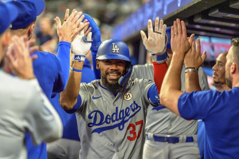 Teoscar Hernández celebrates in the dugout after hitting a home run for the Dodgers against the Braves.