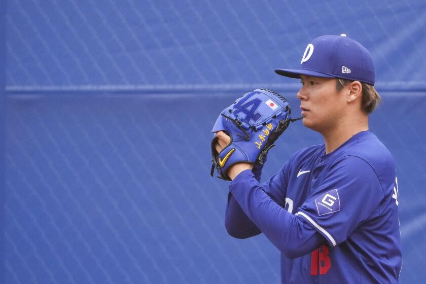 Los Angeles Dodgers pitcher Yoshinobu Yamamoto throws a bullpen session during spring training baseball workouts Monday, Feb. 26, 2024, in Phoenix. (AP Photo/Lindsey Wasson)