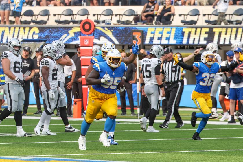 The Chargers celebrate after Poona Ford's (95) interception sealed a victory over the Raiders. 