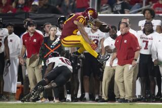 USC receiver Kyle Ford leaps over Rutgers defensive back Flip Dixon during the Trojans' win Friday night at the Coliseum