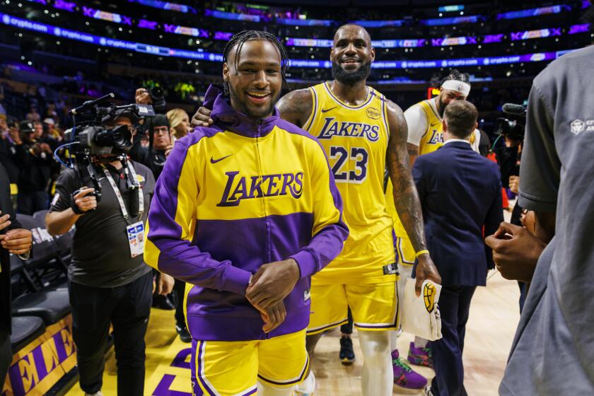 LOS ANGELES, CA - OCTOBER 22, 2024: Los Angeles Lakers guard Bronny James (9) and Los Angeles Lakers forward LeBron James (23) leaves the court after a win over the Minnesota Timberwolves in the home opener at Crypto.com Arena on October 22, 2024 in Los Angeles, California. (Gina Ferazzi / Los Angeles Times)