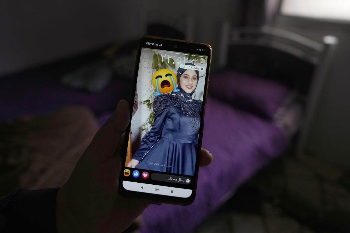 A person holds a phone that shows a photo of a smiling girl.