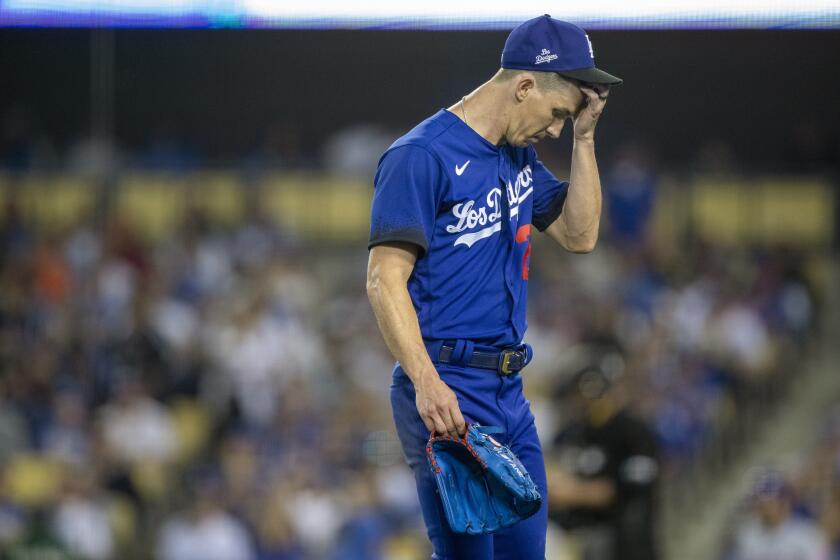 Los Angeles Dodgers' Walker Buehler walks off the field after manager Dave Roberts.