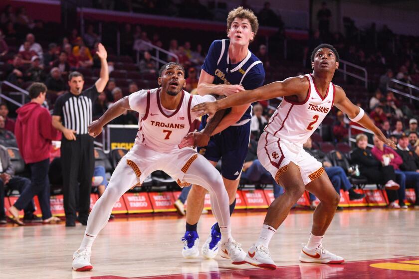 USC guard Chibuzo Agbo, left, and forward Isaiah Elohim, right, box out Chattanooga forward Sean Cusano.