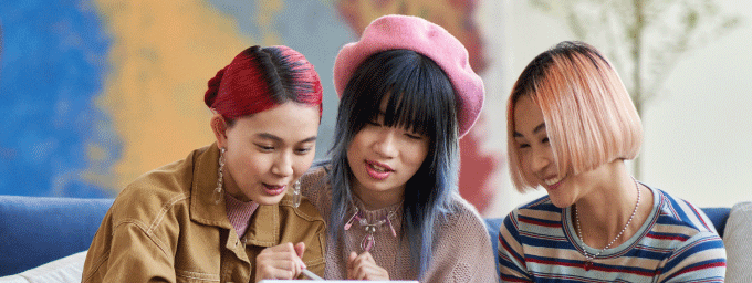 Photo of 3 students looking at tablet