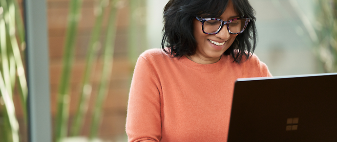 A person smiling while looking at a computer