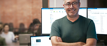 A man standing in front of several monitors.