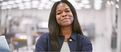 A black woman smiling in front of a computer