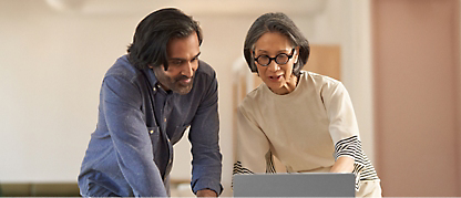 Two persons discussing while working on the laptop