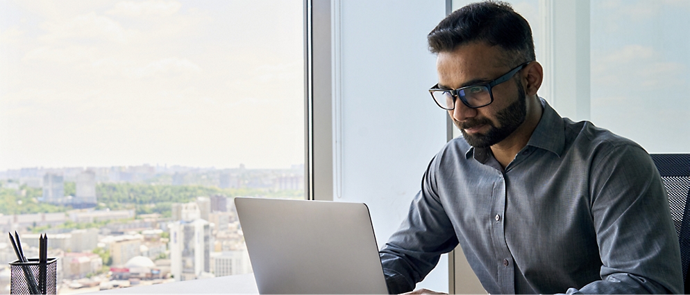 Personne assise à un bureau avec un ordinateur