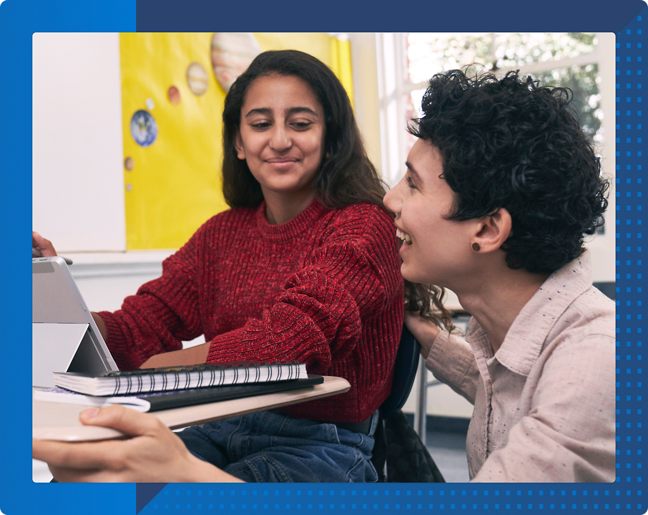 A young person and another person looking at a computer