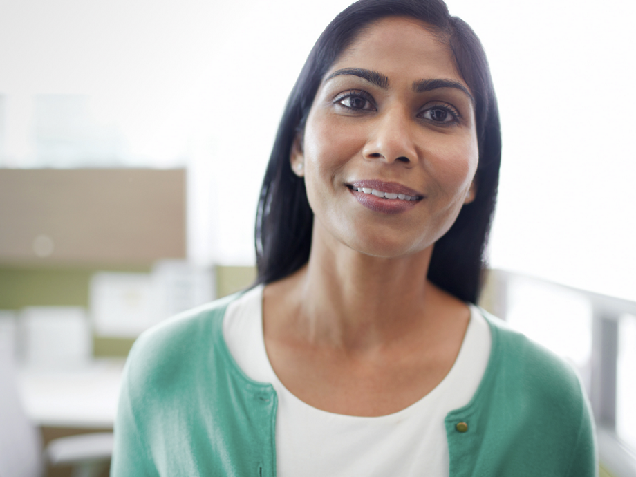 A woman wearing green sweater and smiling