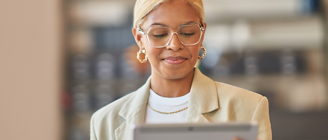 A person wearing glasses and a tan jacket