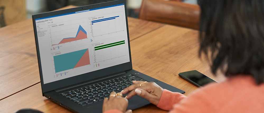 Person working on a laptop with data charts displayed on the screen