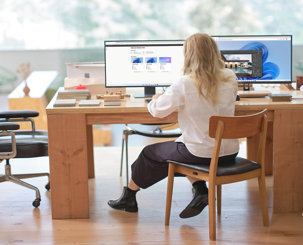 Egy íróasztalnál ülő, számítógépet néző személy