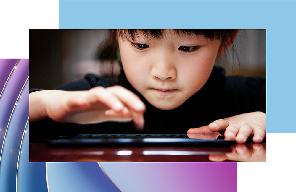 Enfant se concentrant sur l’utilisation d’une tablette numérique.