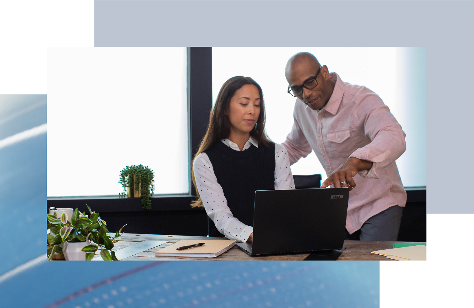 A person and another person looking at a computer