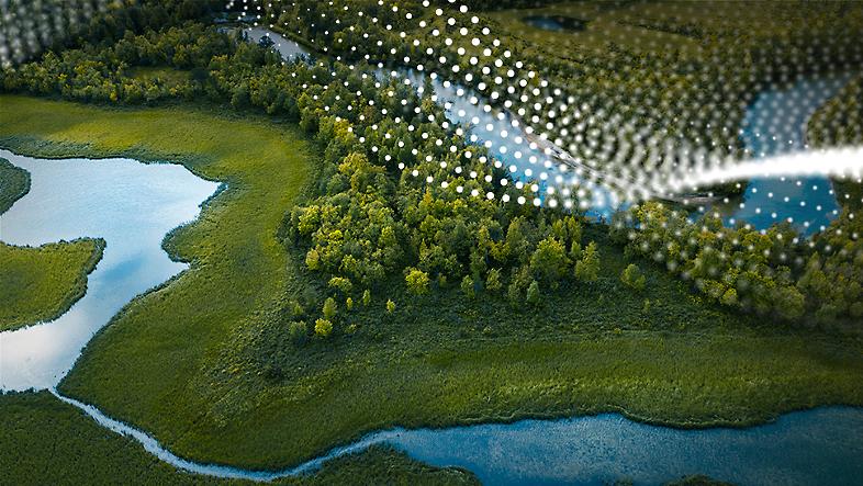 An overhead view of forested land with a river running through it.