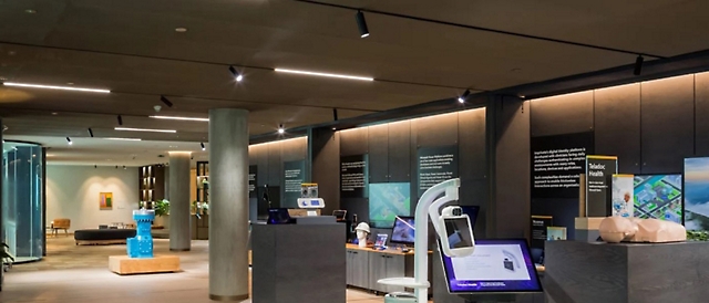 Interior de una exposición moderna de un jurado con pantallas interactivas, paneles informativos y elementos de diseño elegantes.