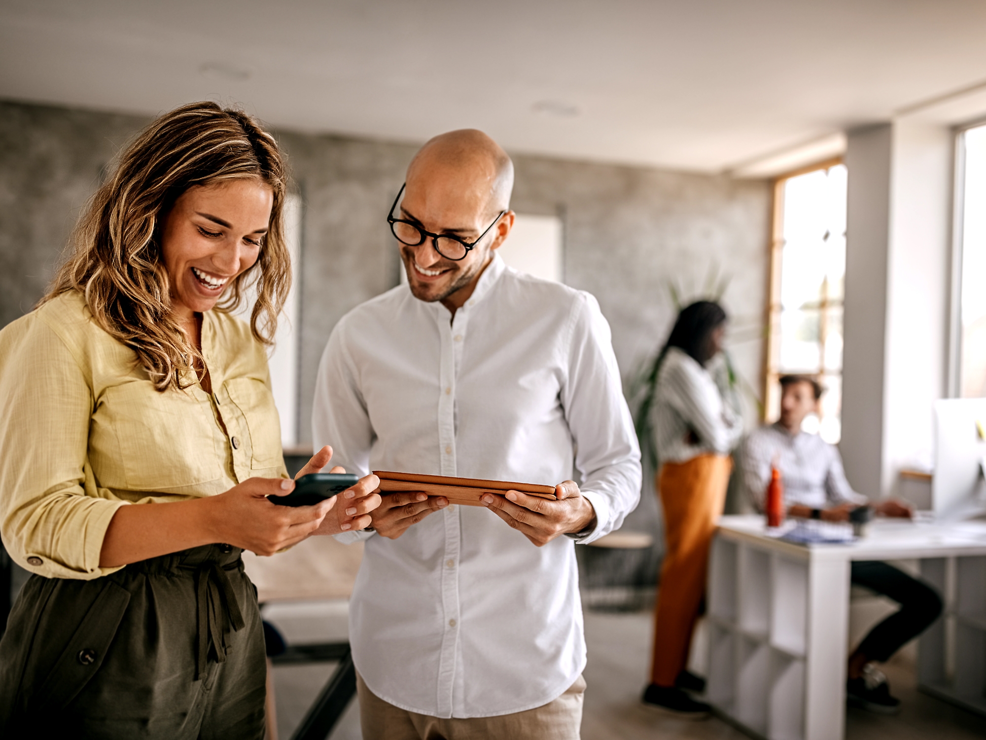 A person and another person looking at a tablet