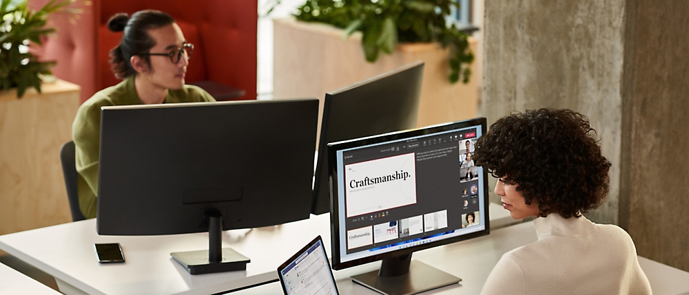 A group of people sitting at a desk with computers