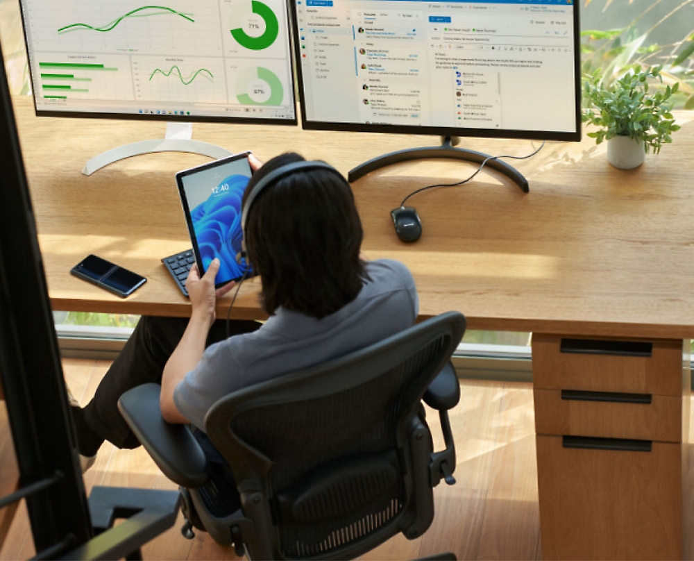 A person sitting at a desk with a tablet