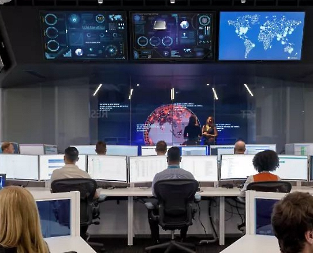 A group of people in a conference room with computers