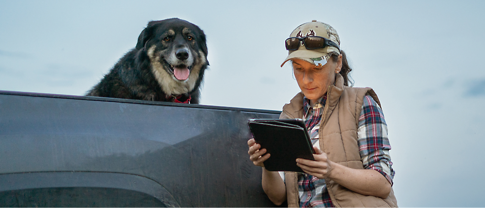 Uma mulher está assistindo ao tablet com seu cachorro