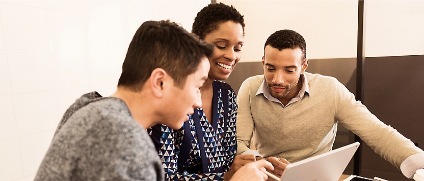 Three people are sitting together in a meeting.