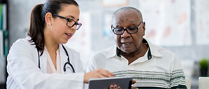 A person and another person looking at a tablet