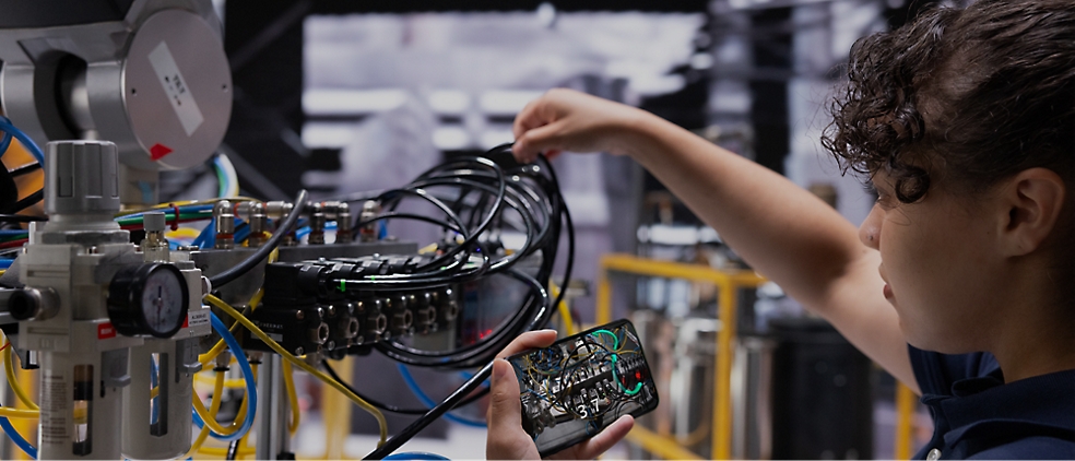 A technician adjusts cables connected to a complex electronic setup in a laboratory environment.