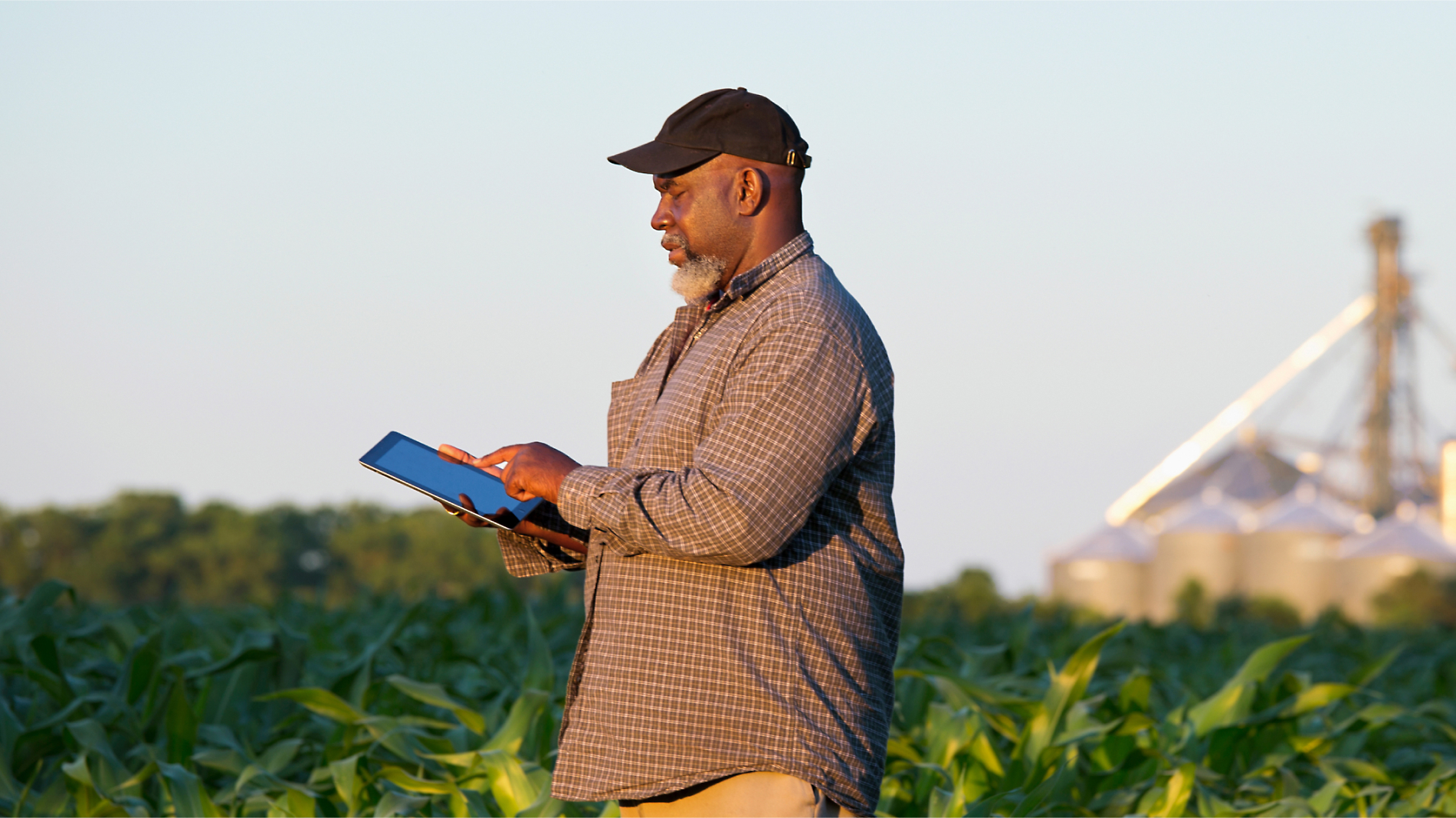 A person holding a tablet in a field