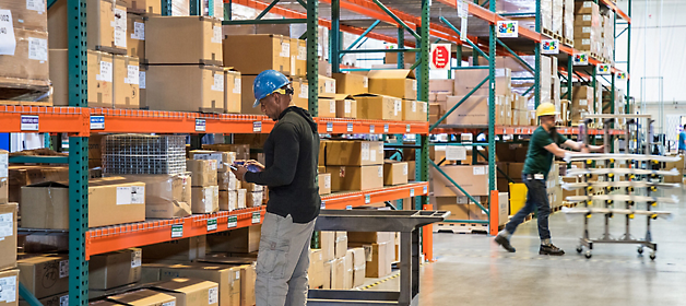 Workers inventorying and organizing items in a warehouse.