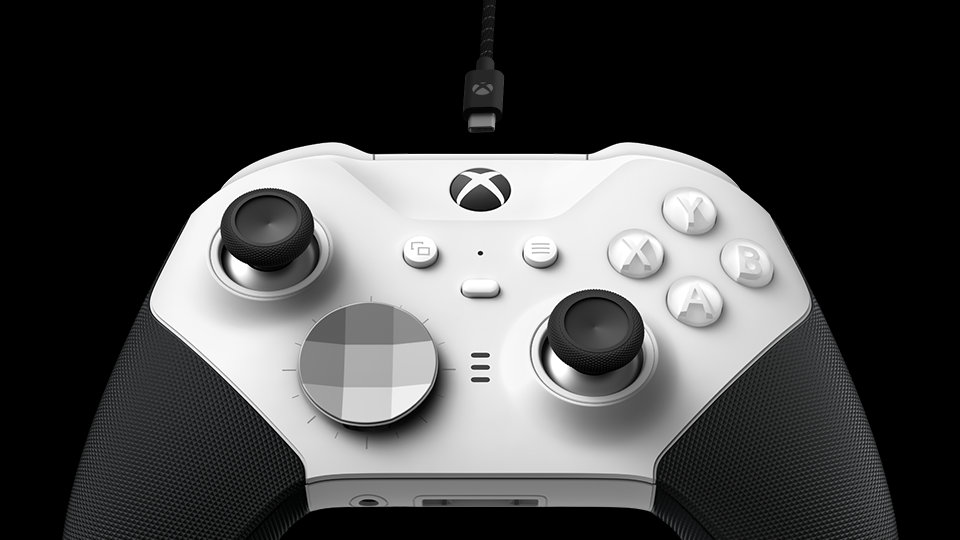 Widok od dołu na kontroler bezprzewodowy Xbox Elite Series 2 – Core (biały) z widocznym kablem USB-C podłączonym w celu ładowania akumulatora.