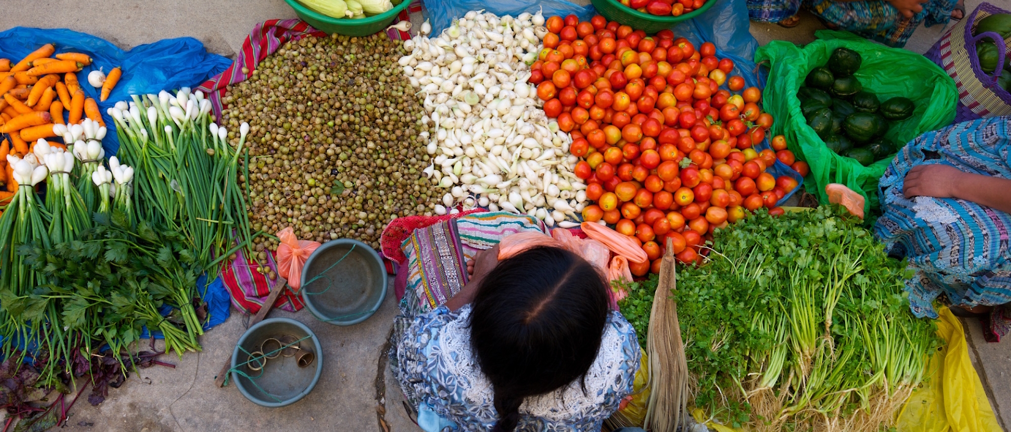 A person sitting at avegetable market