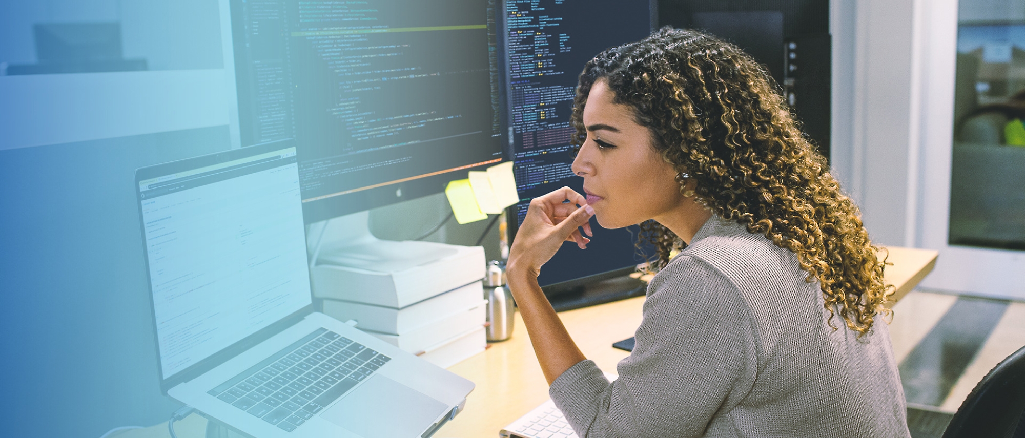 A person sitting at a desk looking at a computer screen