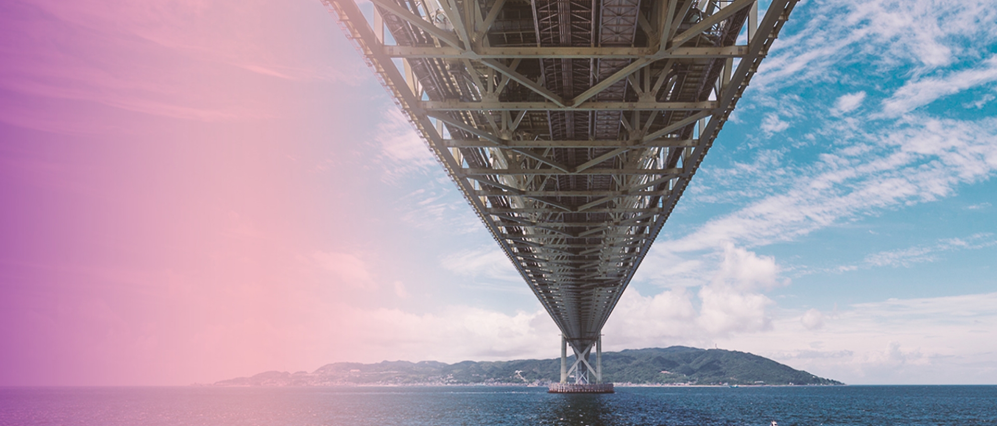 A bridge over water with hills in the background