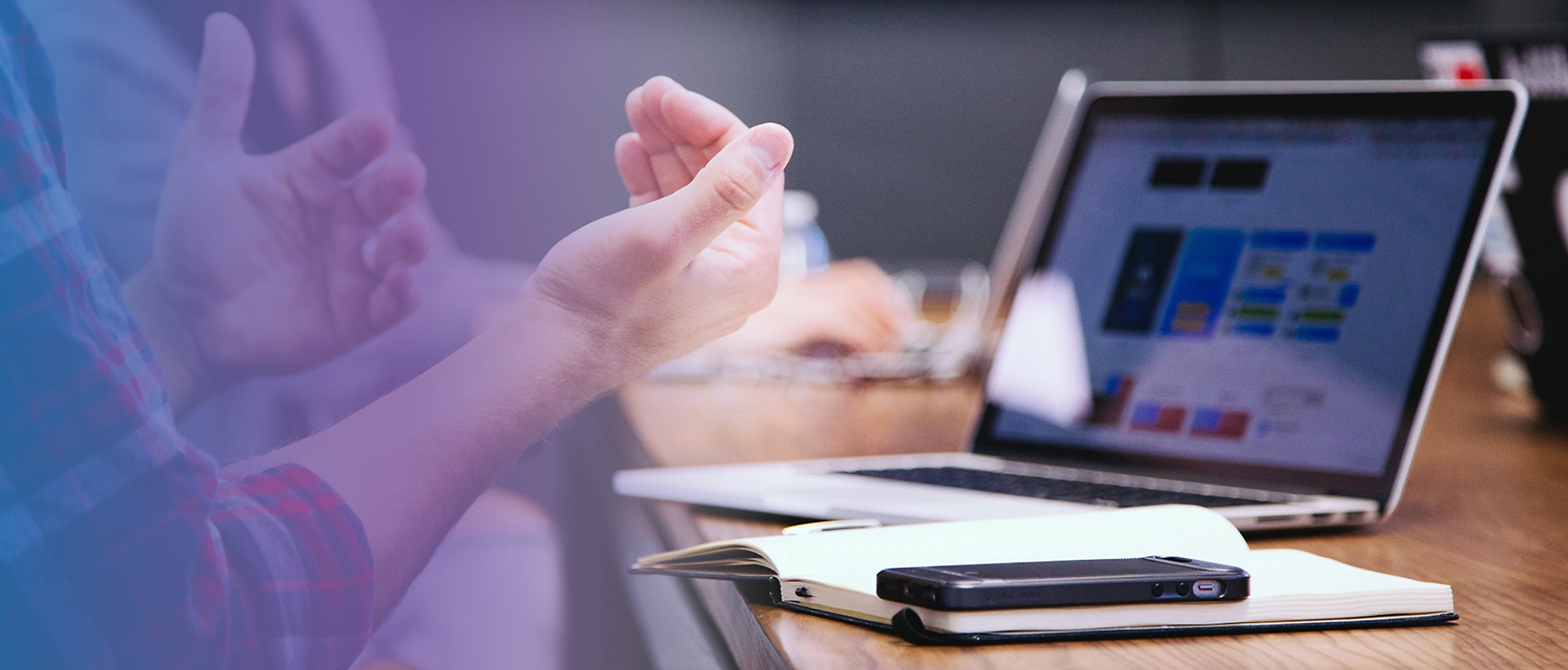 A person raising their hand towards the laptop