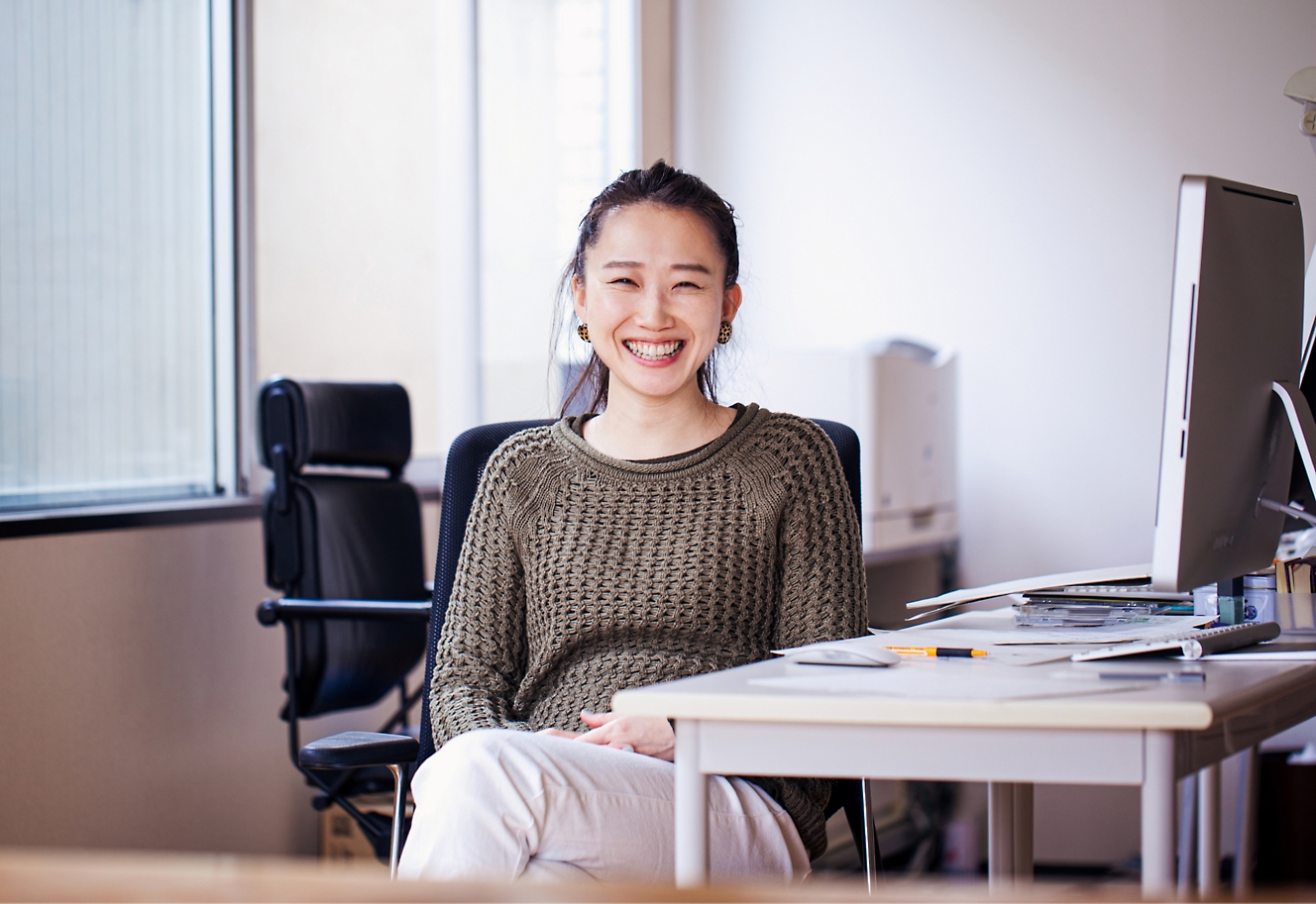 A girl smiling and sitting on a chair