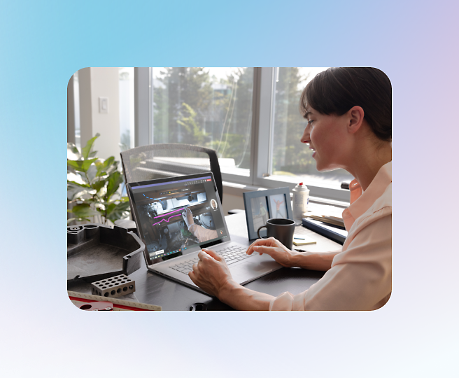 A person sits at a desk, participating in a video call on a laptop.