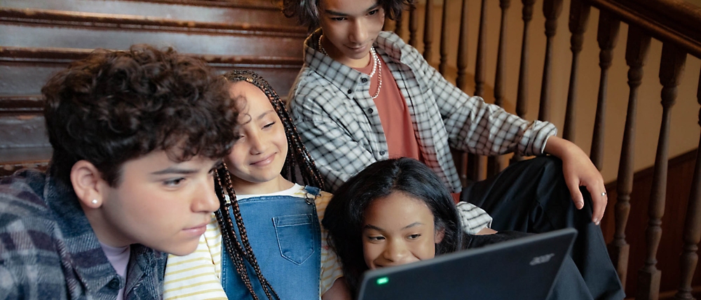 A group of people looking at a computer.