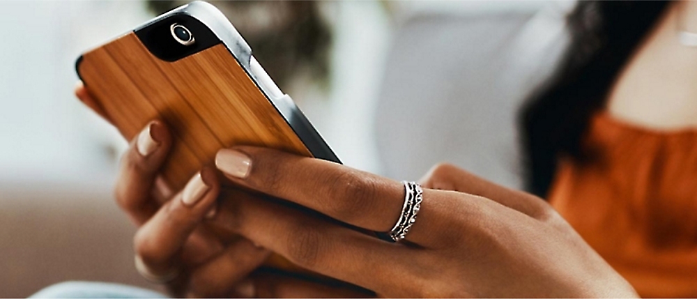 A close-up of a person's hands holding a cell phone