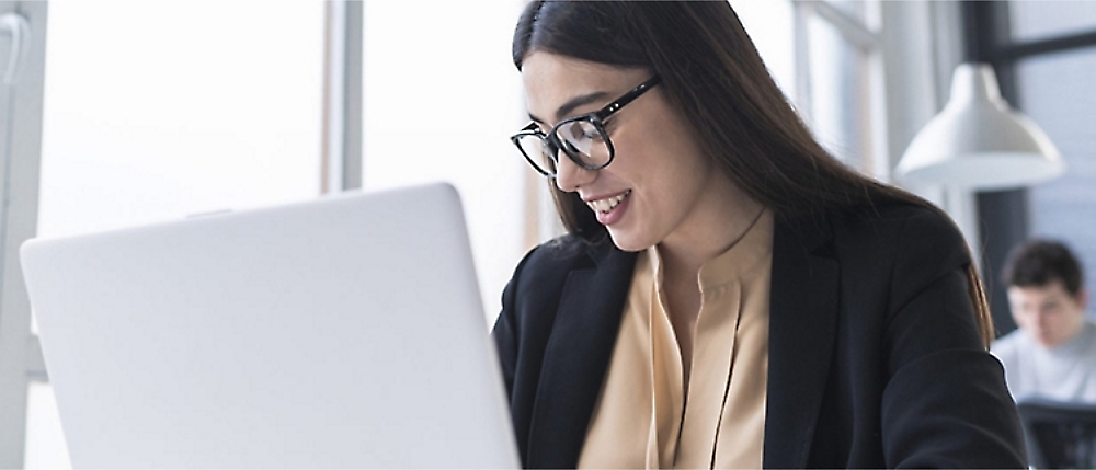 A person in glasses looking at a computer