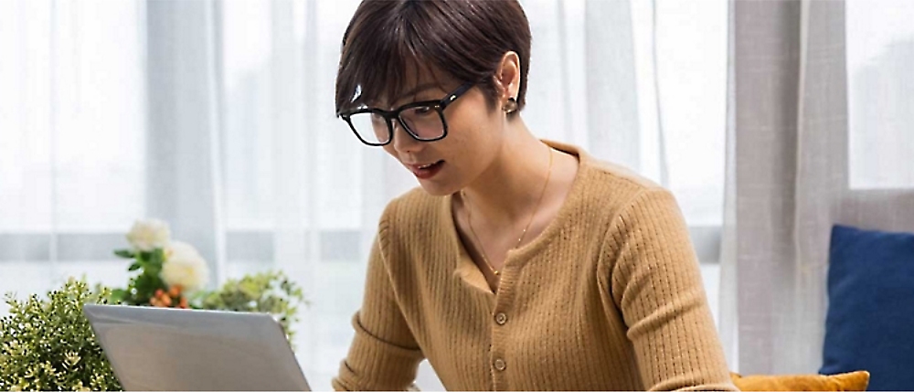 A person in glasses looking at a computer