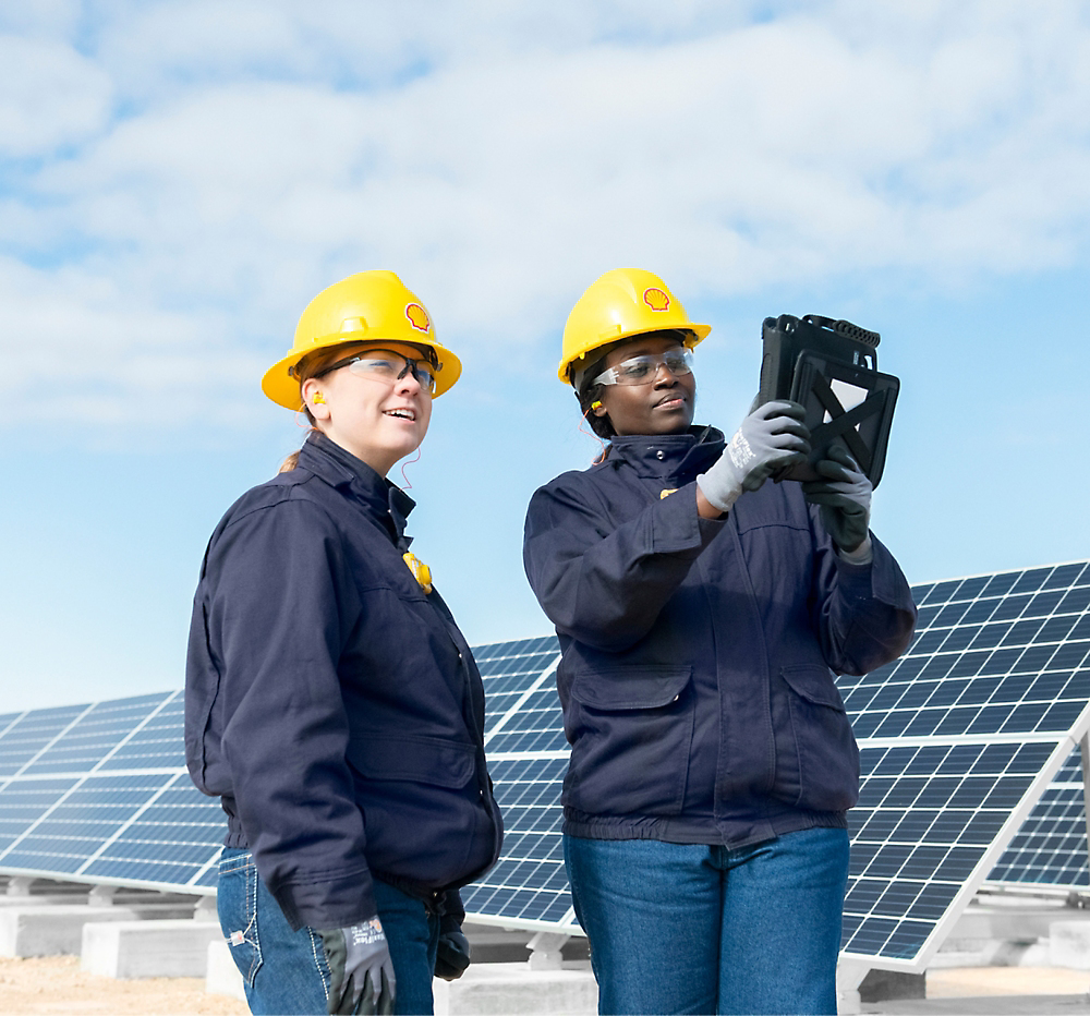 A couple of women in hardhats and helmets