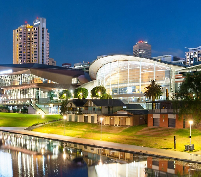 A building with a glass roof and a body of water