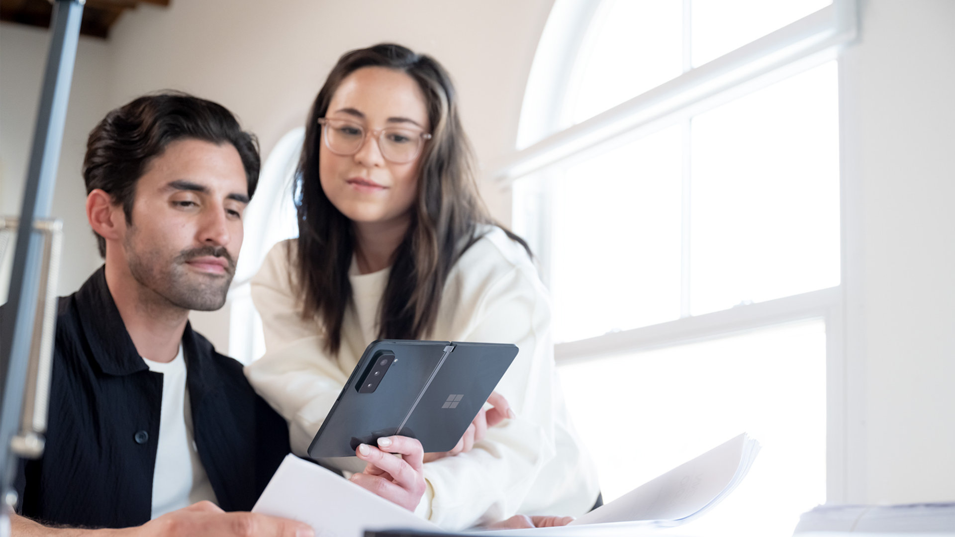 Two people taking a video call with the Surface Duo 2.