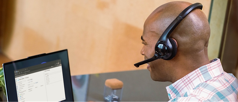 Un hombre sentado en un escritorio con auriculares